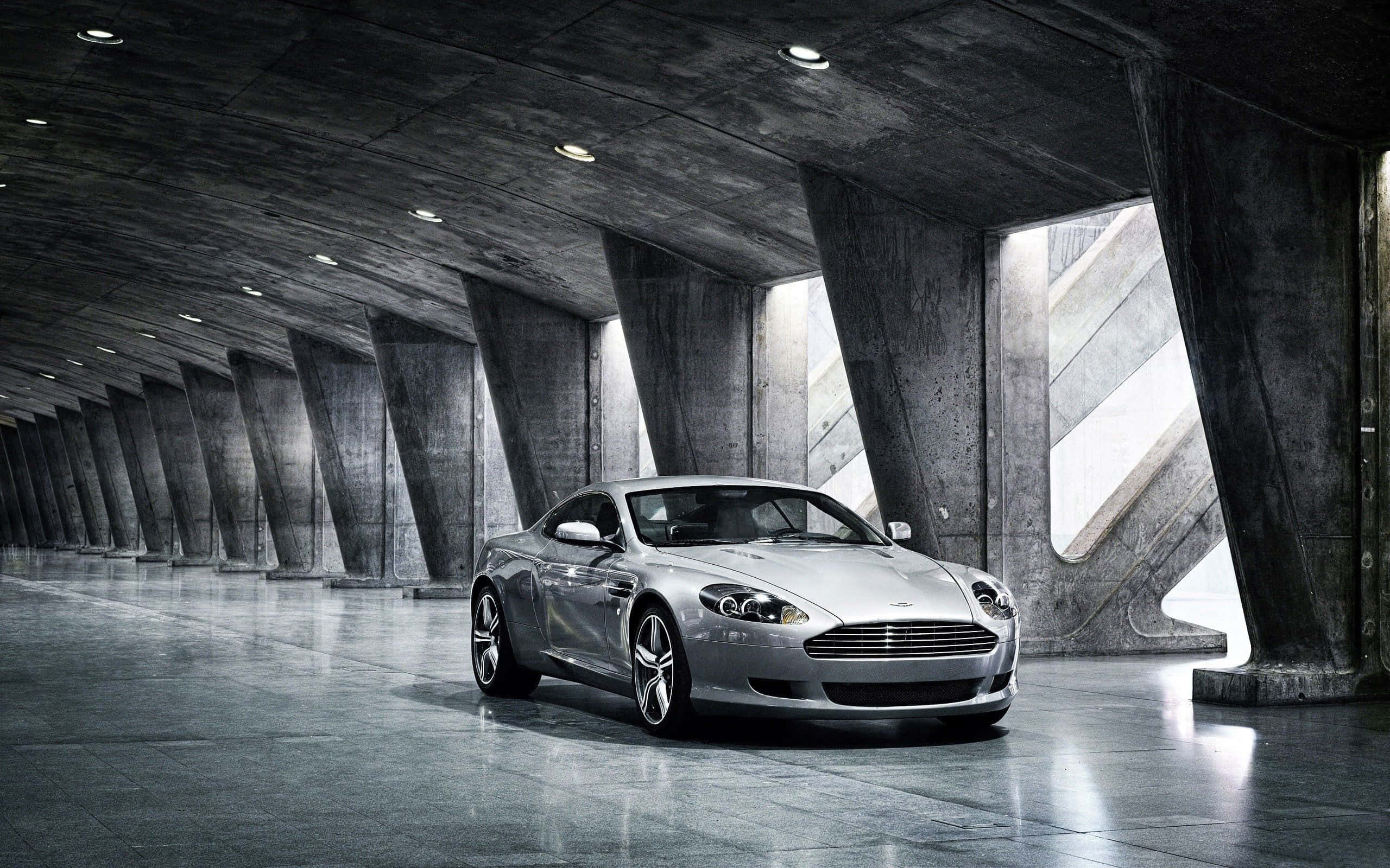 Aston Martin DB9 risteilee maisemallisessa kaupunkimaisemassa Taustakuvat