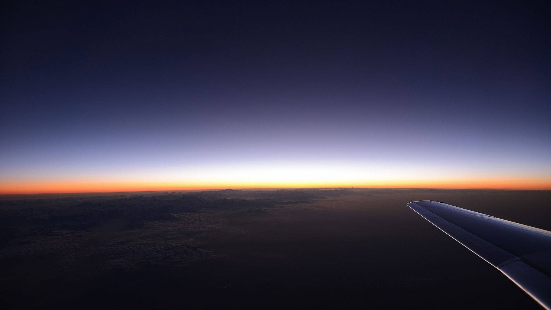 Auringonlaskun taivasnäkymä lentokoneesta Taustakuvat