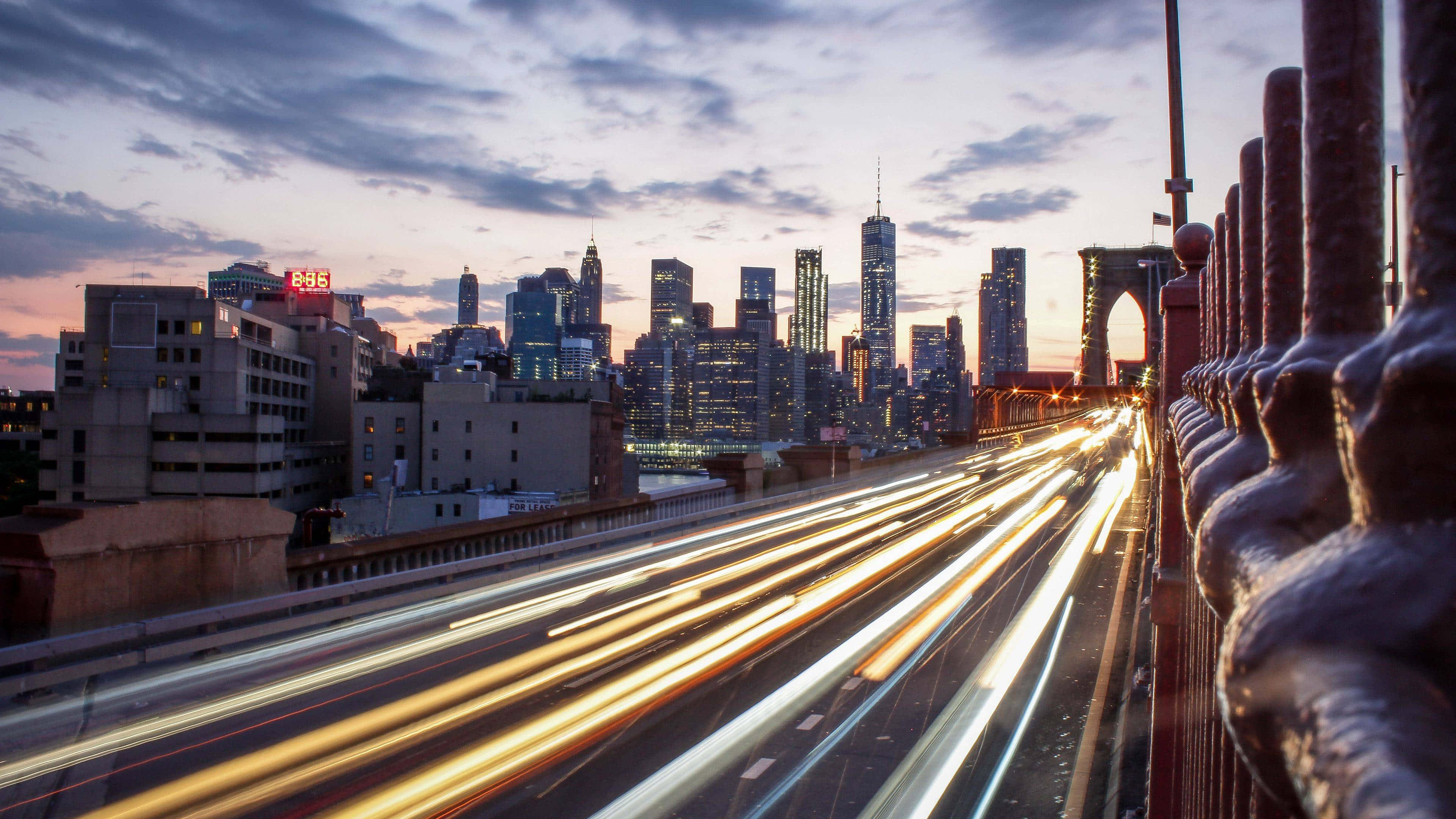 Brooklyn Bridge hämärässä kaupungin valojen kanssa Taustakuvat
