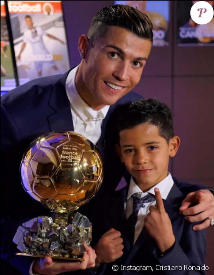 Cristiano Ronaldo kultaisen pallon ja lapsen kanssa Taustakuvat
