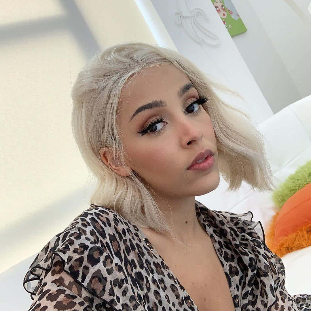 Doja Cat esittelee kauneuttaan glitterluomivärillä ja kirkkaalla hymyllä. Taustakuvat