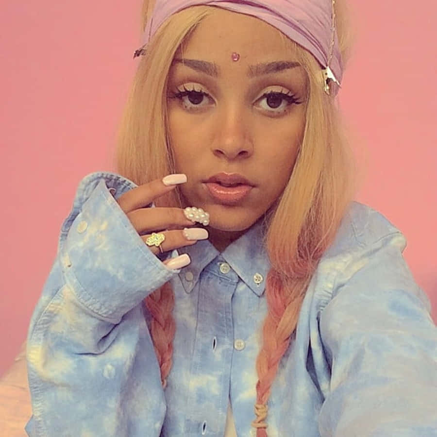 Doja Cat loistaa värikkäissä letissä, jotka ovat hänen tavaramerkkinsä Taustakuvat