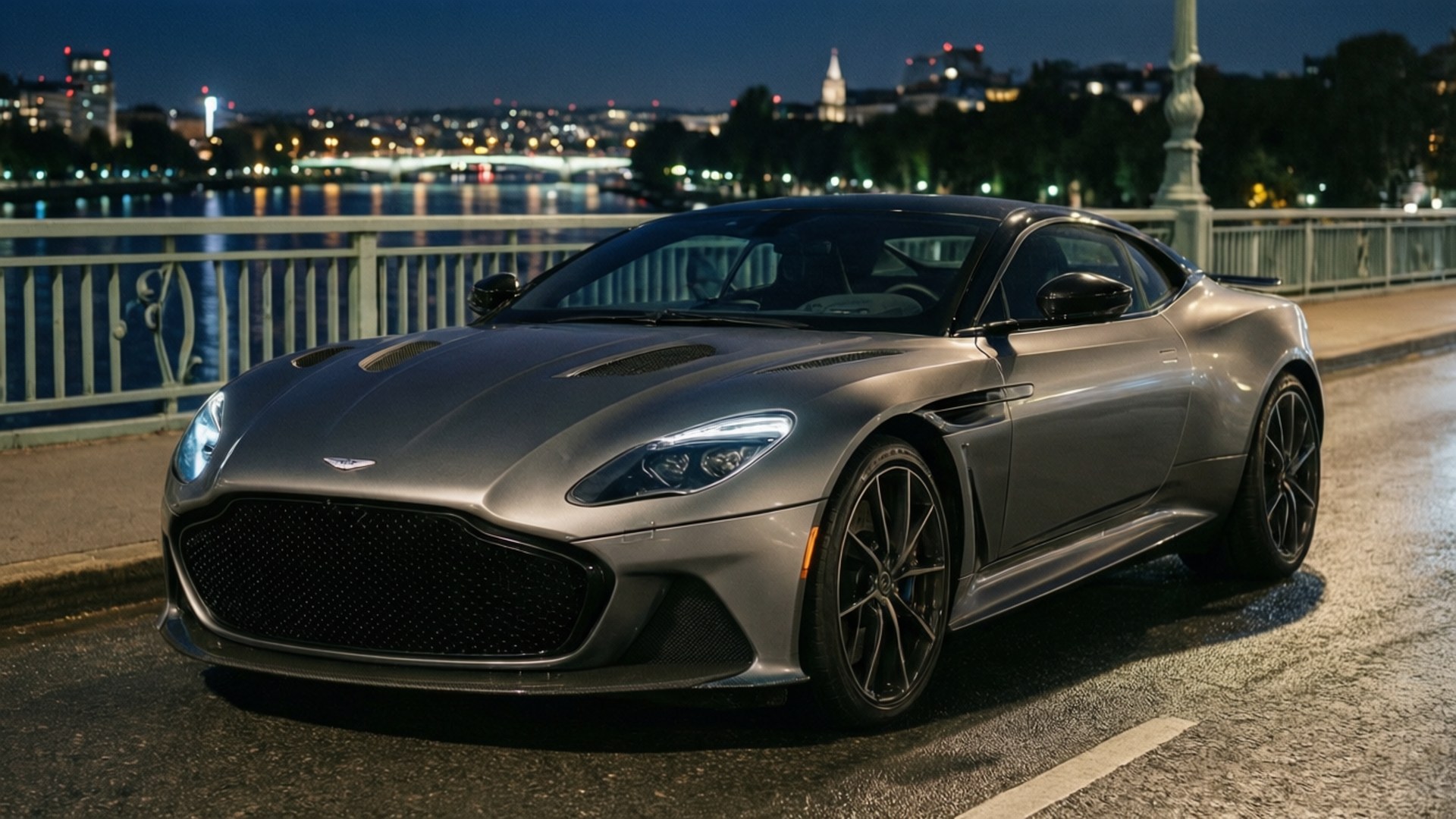 Aston Martin DBS Superleggera sillalla yöllä kaupungin valojen kanssa. — Hienot autot GIF Taustakuvat