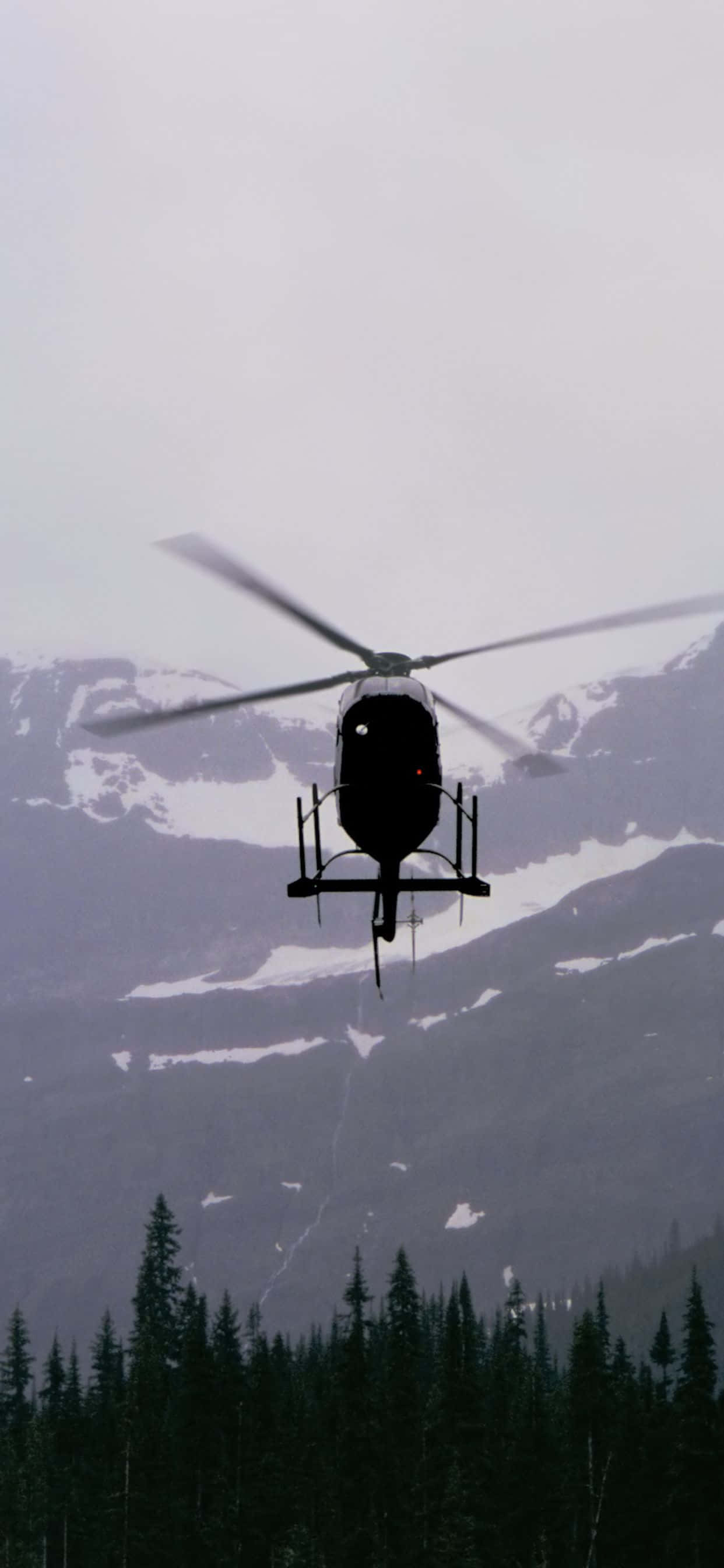 helikopteri lentämässä vuorijonon yli Taustakuvat