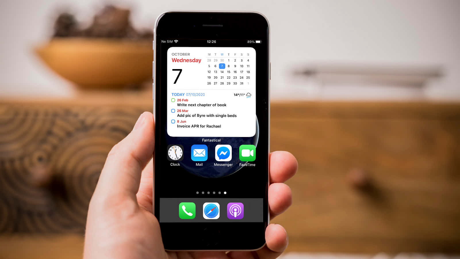 henkilö pitämässä iPhonea, jossa on kalenteri Taustakuvat