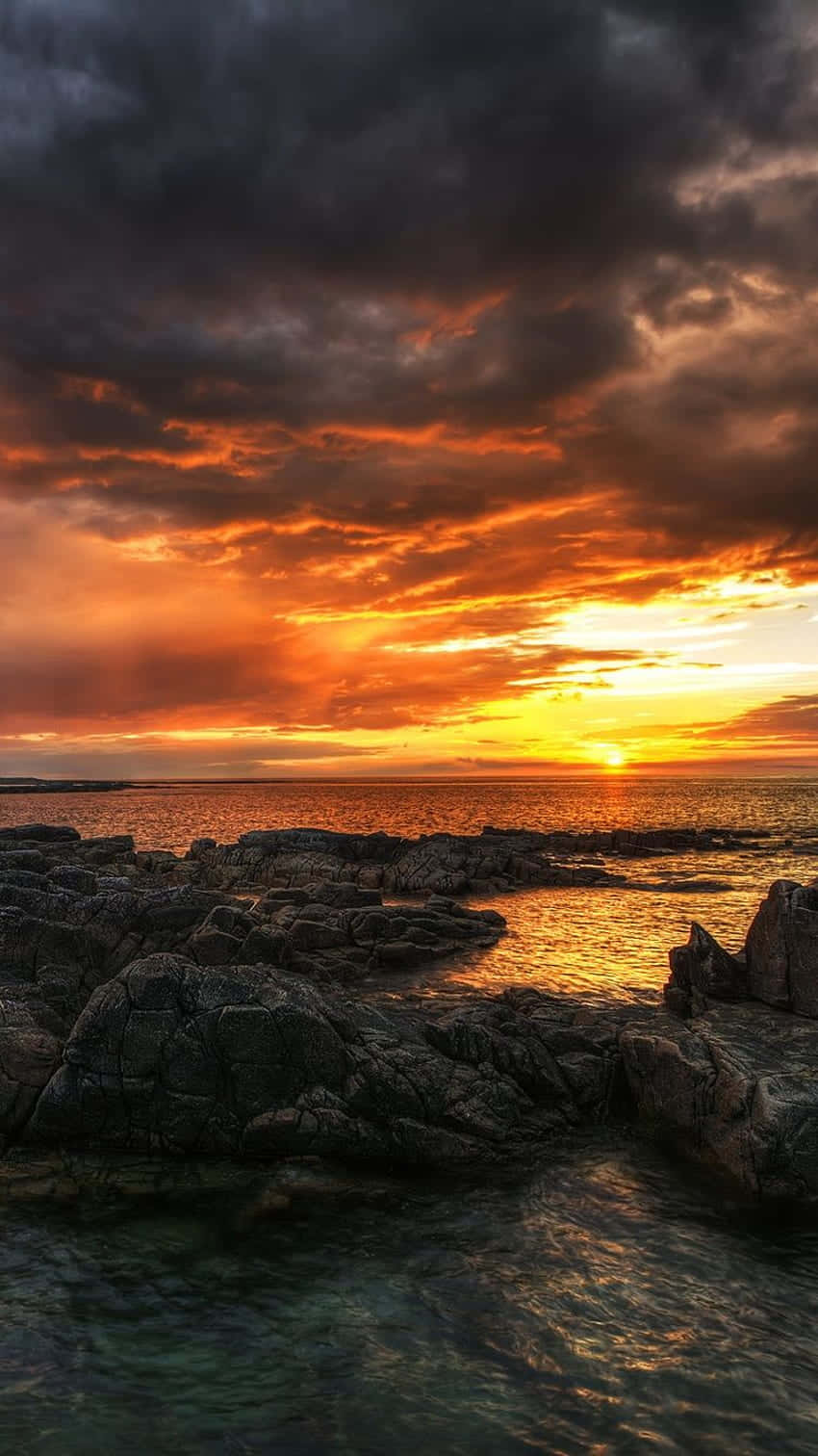 iPhone X Malibu -tausta myrskyisellä auringonlaskutaivaalla Taustakuvat