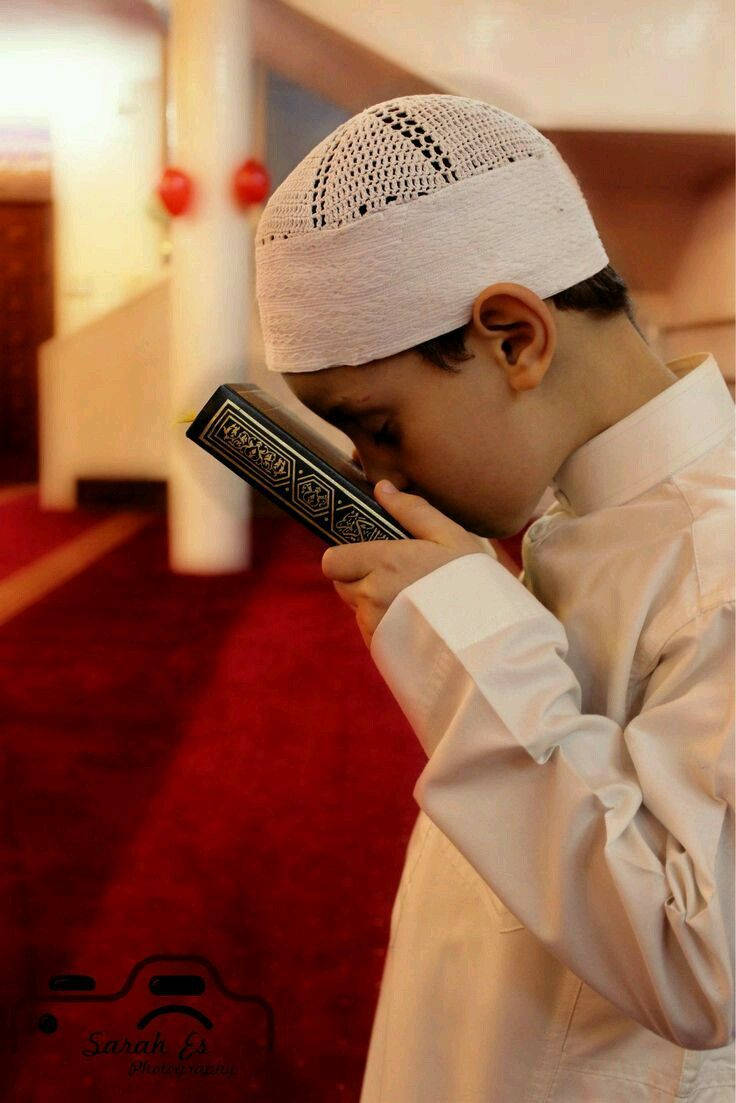 Islamilainen poika suutelee Koraania Taustakuvat