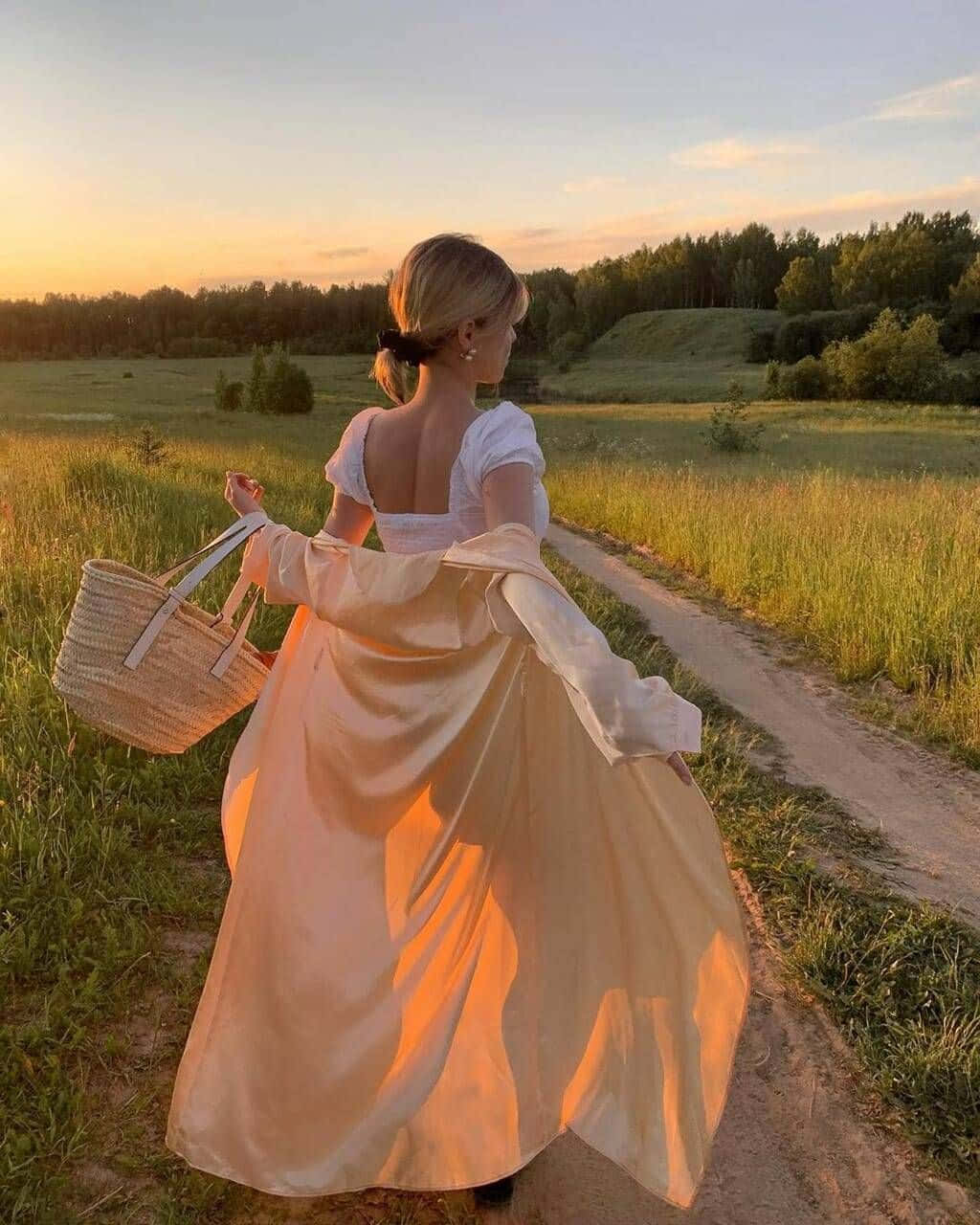 Itsevarma nuori nainen seisoo auringonlaskun taustalla. Taustakuvat