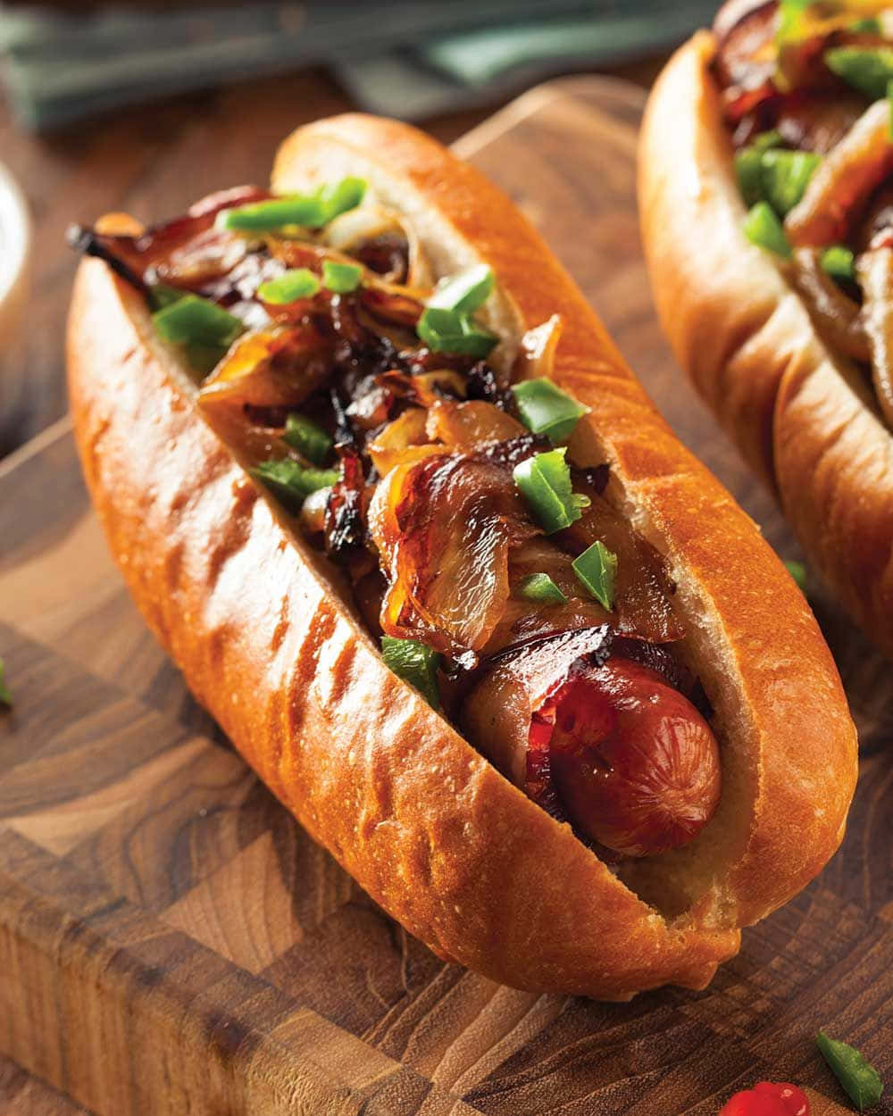 kaksi hot dogia sipulilla ja pekonilla leikkuulaudalla Taustakuvat