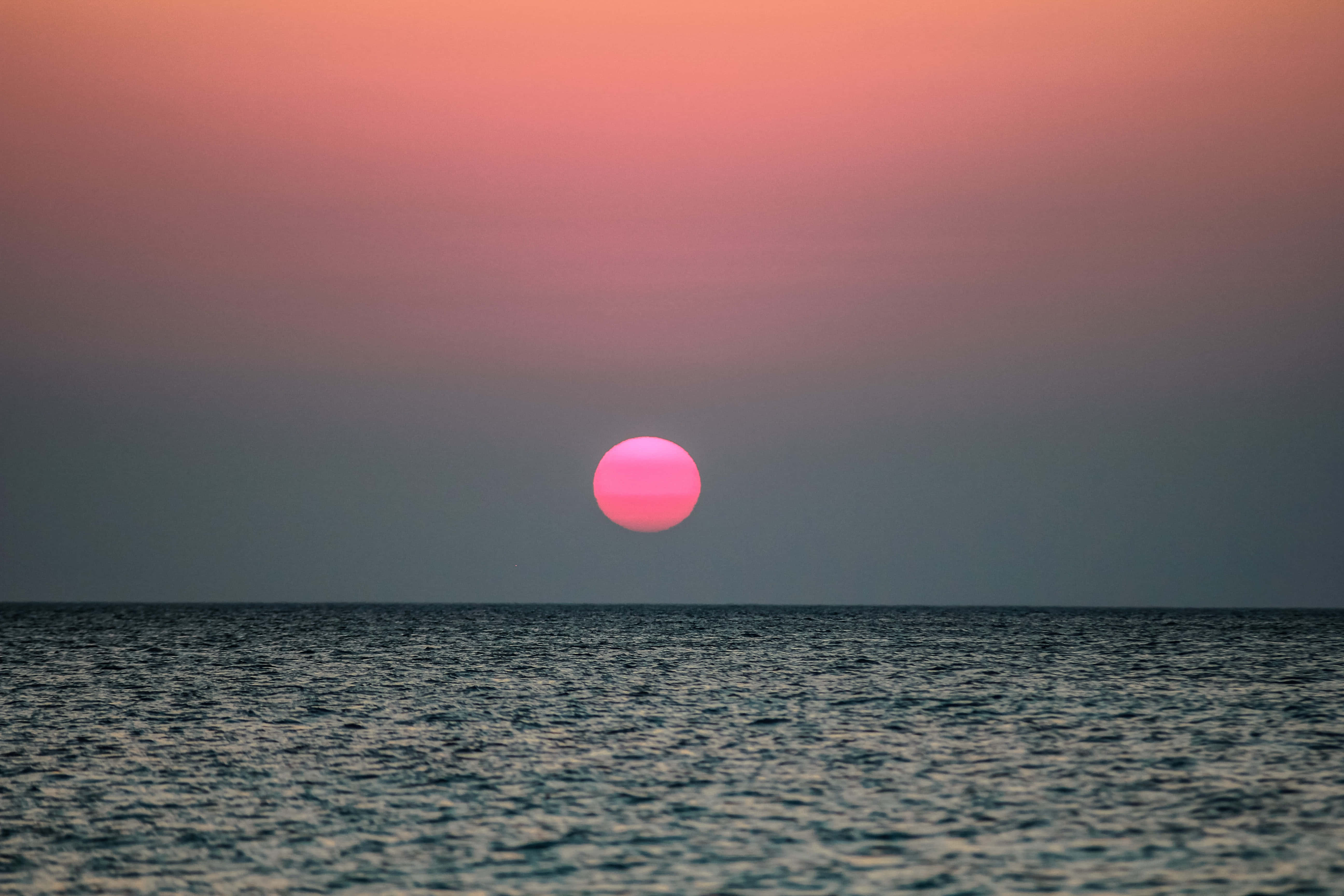 Kaunis auringonlasku maalaa taivaan lämpimin värein. Taustakuvat