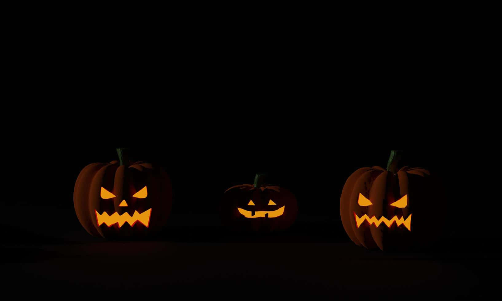 Kolme Halloween-kurpitsaa tumma tausta Taustakuvat