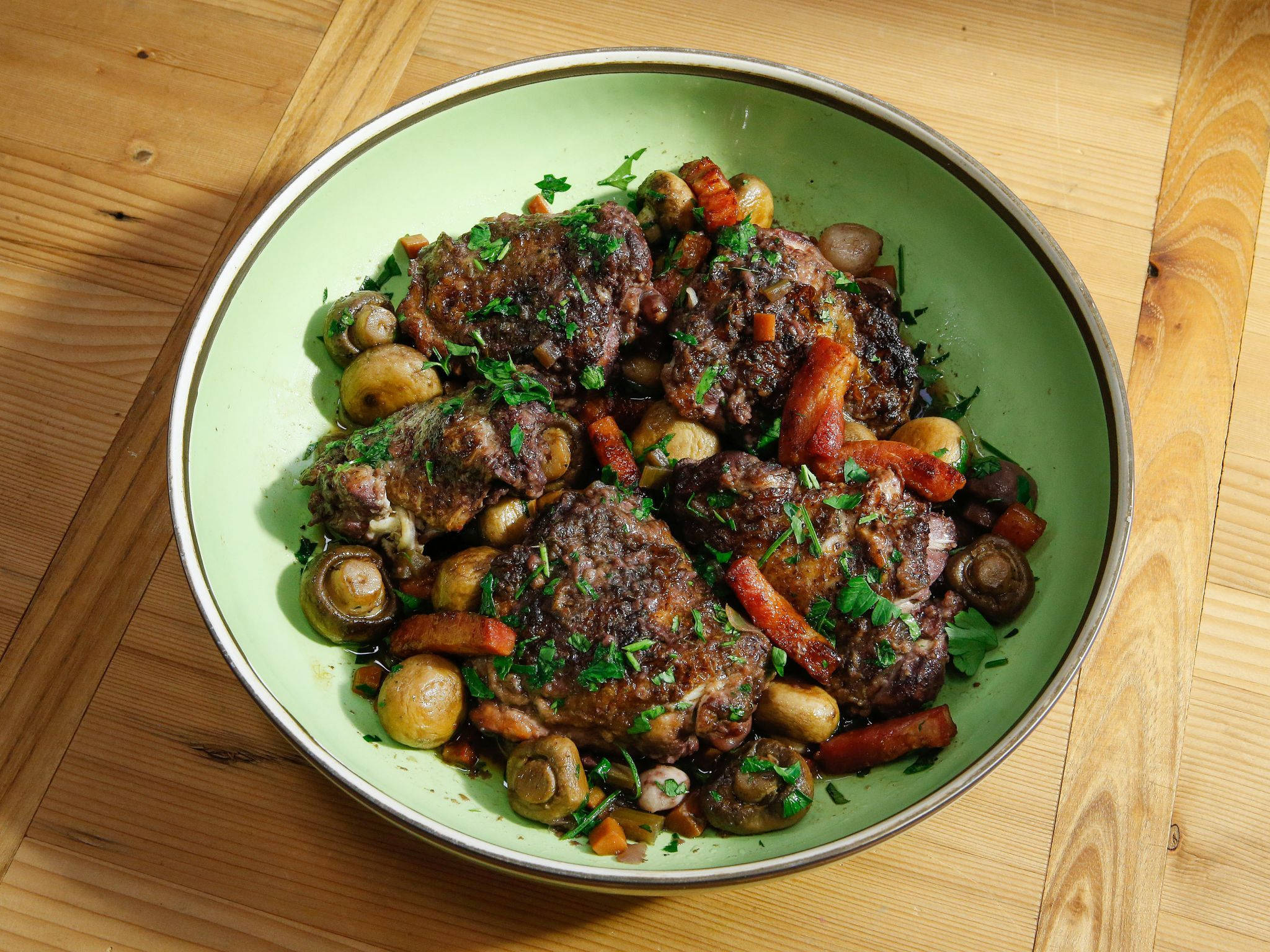 Kuiva coq au vin vihreällä pyöreällä lautasella Taustakuvat