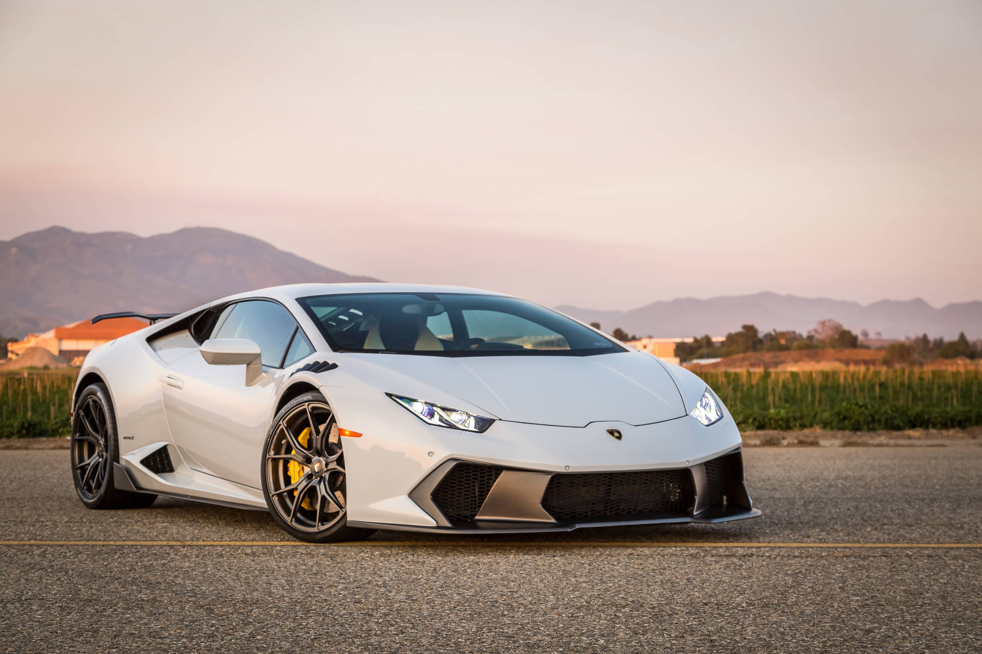 Valkoinen Lamborghini Huracan auringonlaskussa taustakuva.