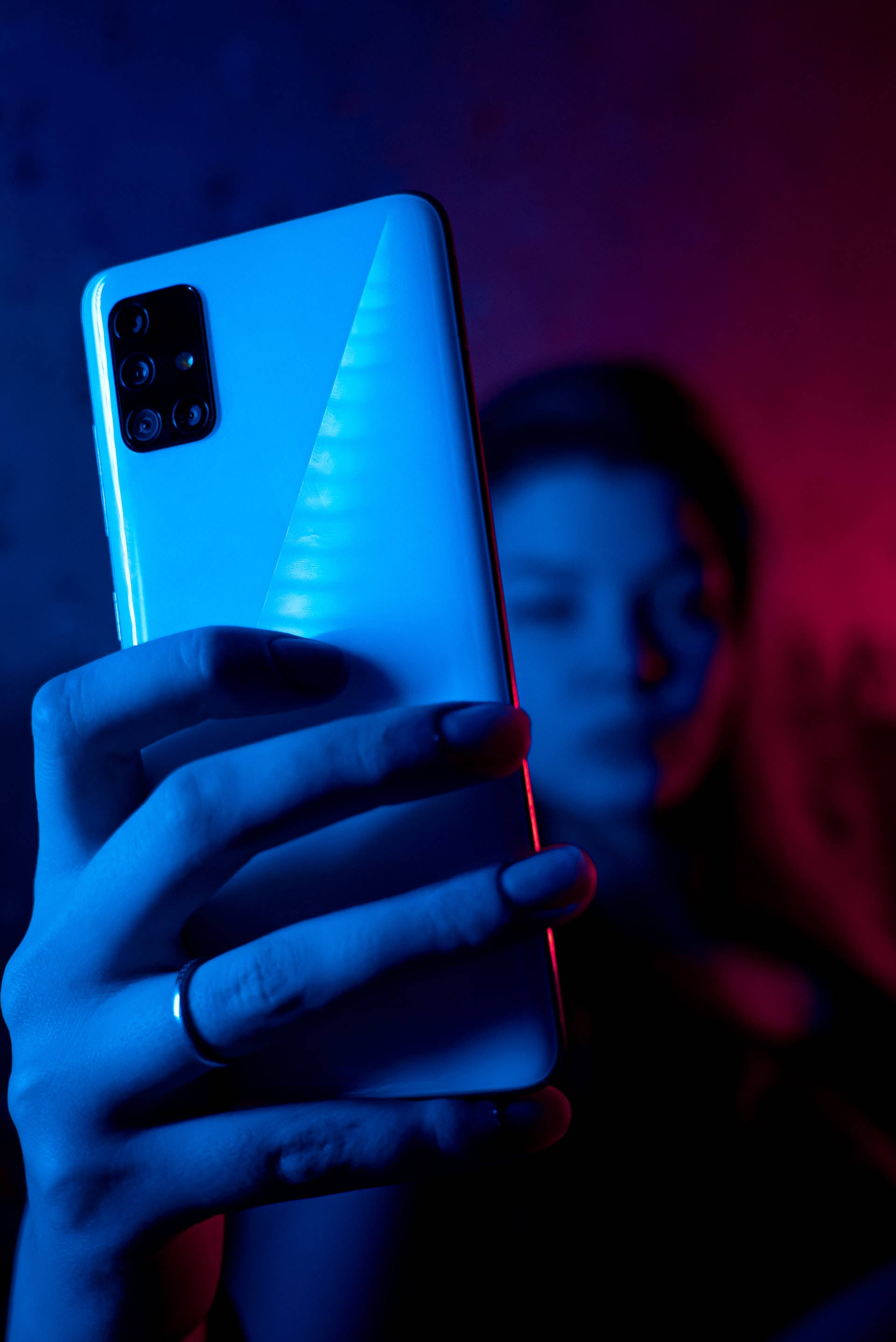 Nainen puhelimen kanssa neoninsinisessä iPhonessa Taustakuvat