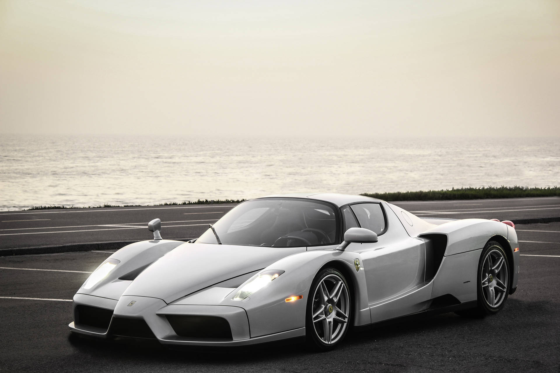 Tyylikäs hopeinen Ferrari Enzo meritaustalla taustakuva.