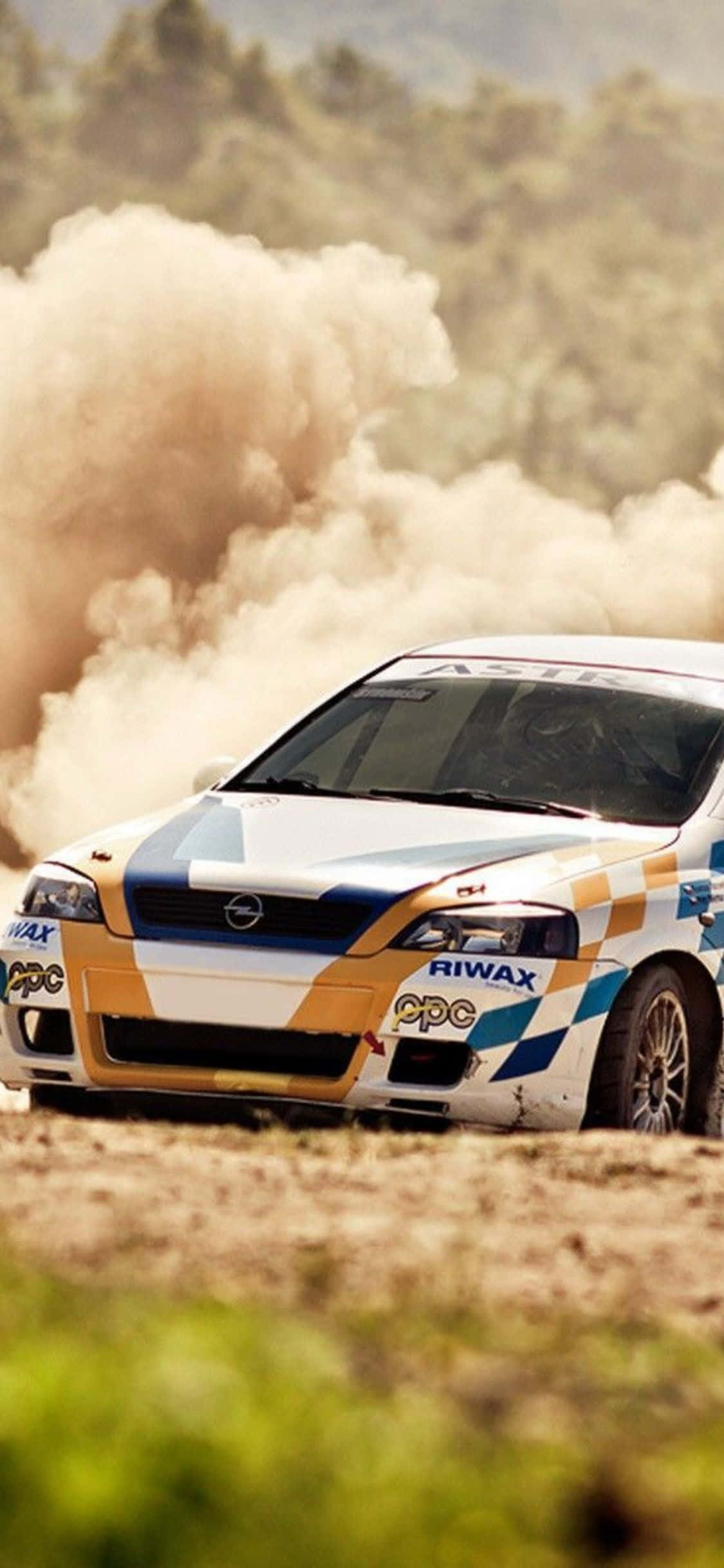 ralliauto ajaa pölyisen pellon läpi Taustakuvat