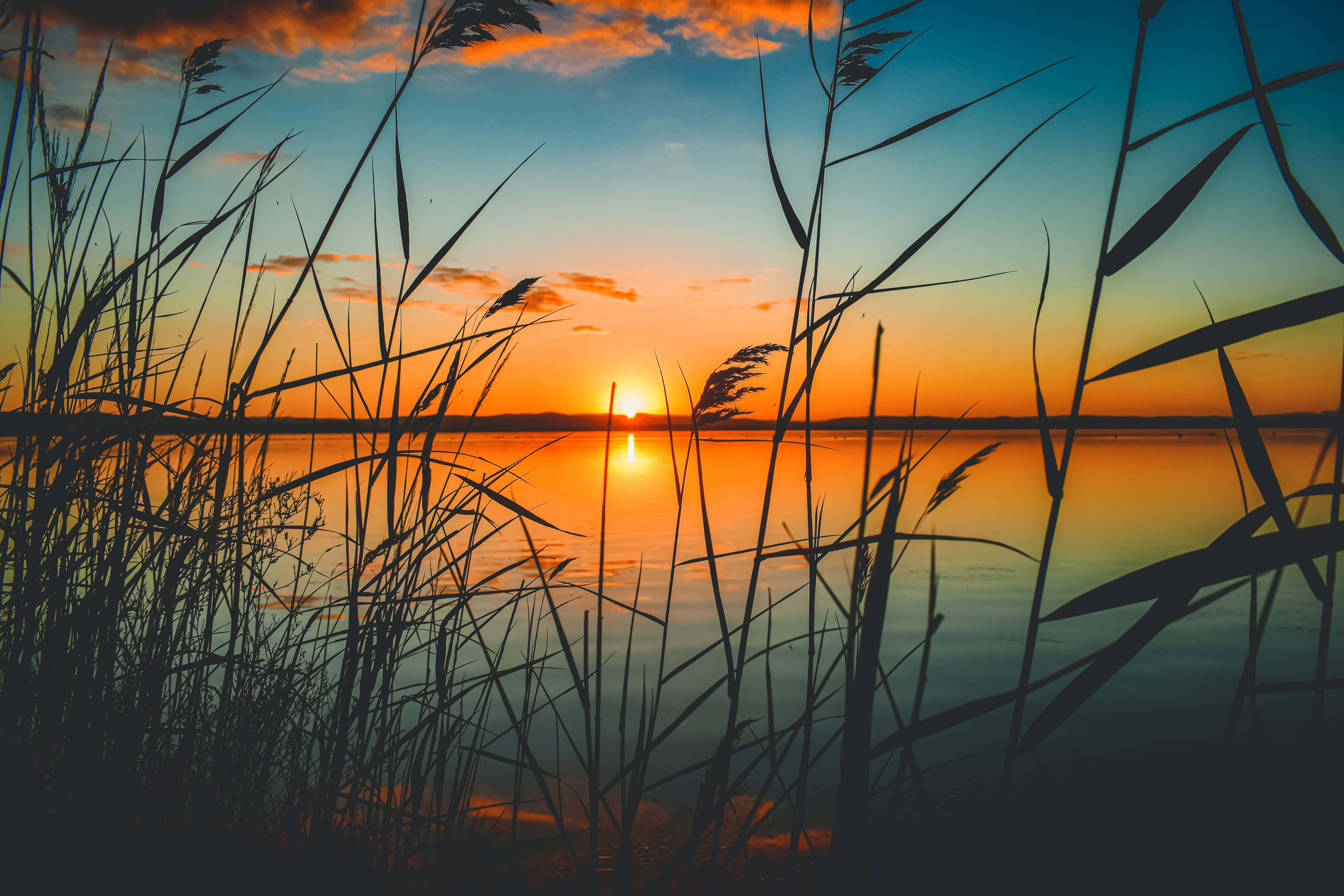 Rauhallinen auringonlasku tyynen järven yllä Taustakuvat