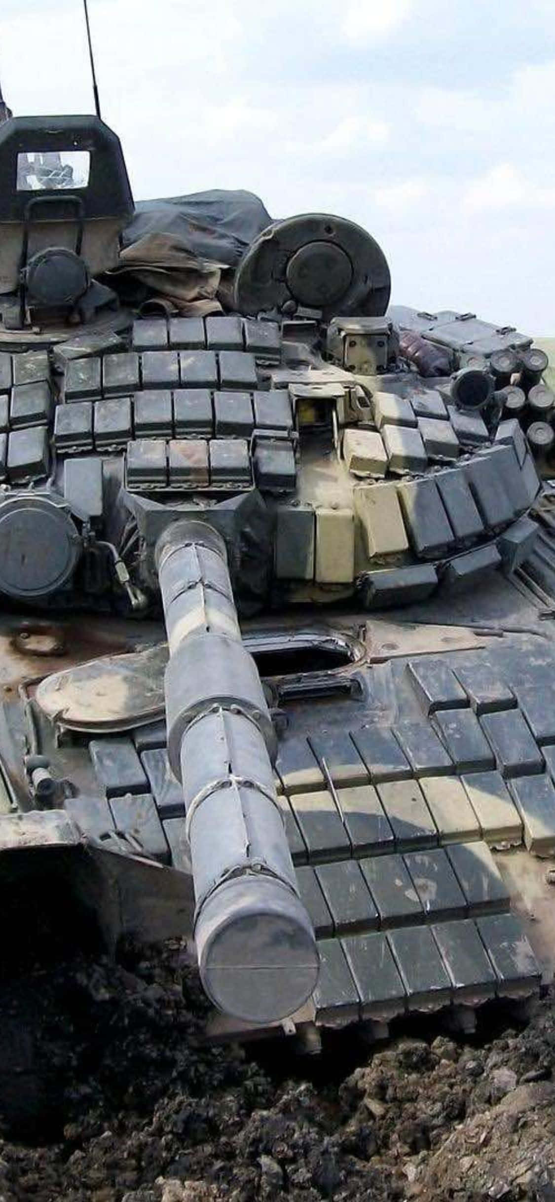 tankki istuu maassa suuren määrän varusteita ympärillään Taustakuvat