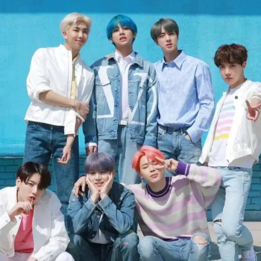 Suloinen BTS-ryhmä poseeraa yhdessä sinisellä seinällä Taustakuvat