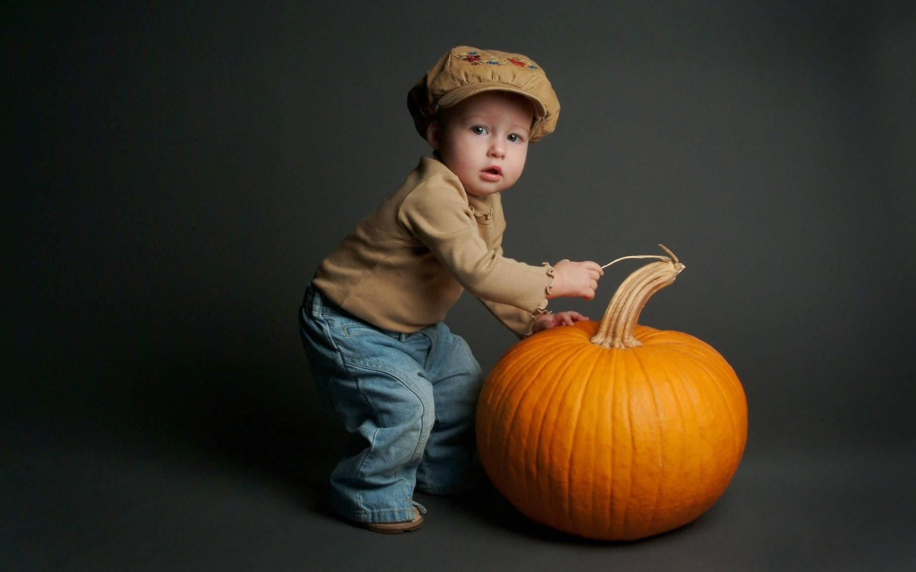 Suloinen Halloween-taapero kurpitsan yllä Taustakuvat