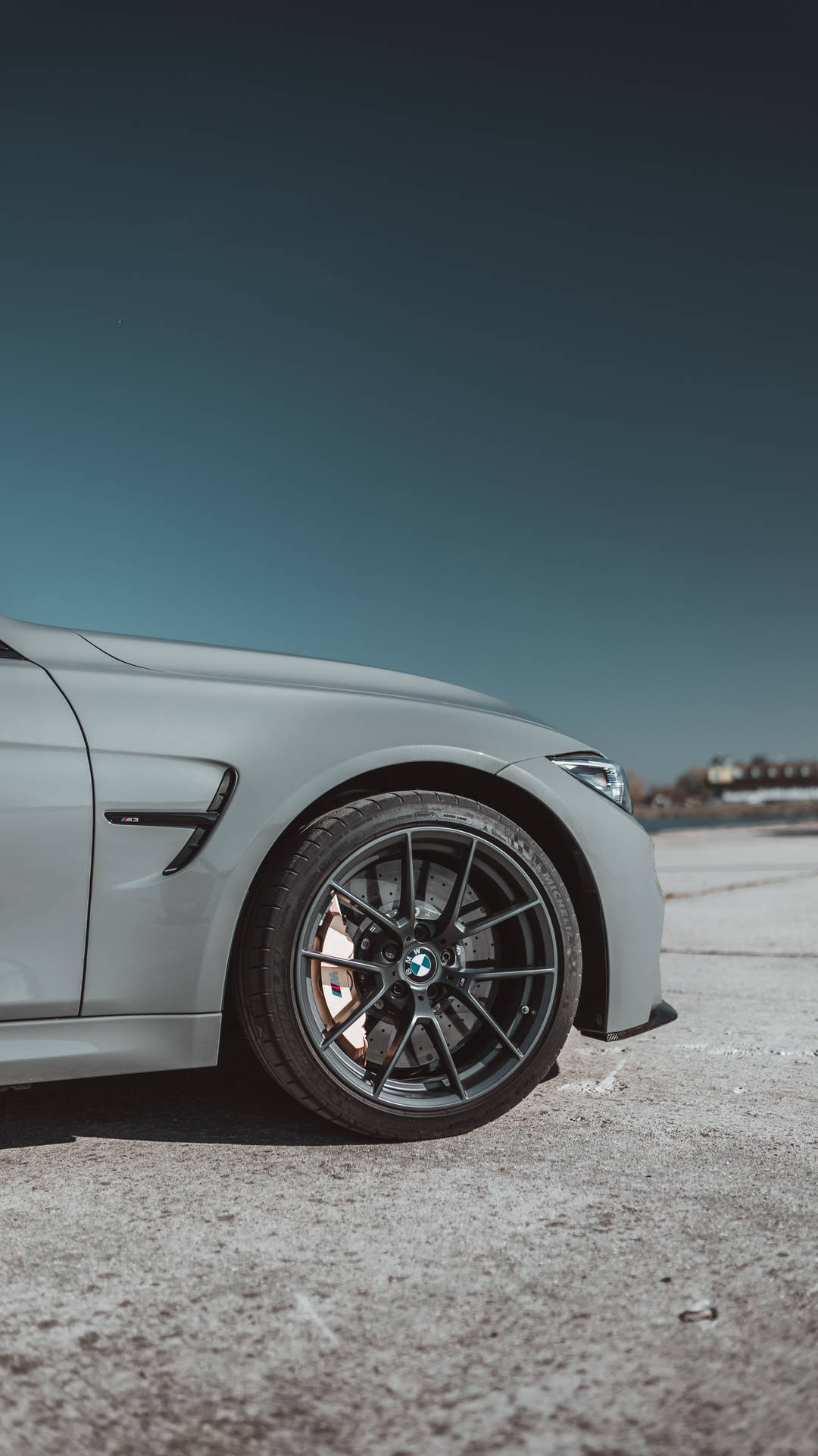 Sivukuva taustakuva harmaan BMW-auton pyörästä logolla