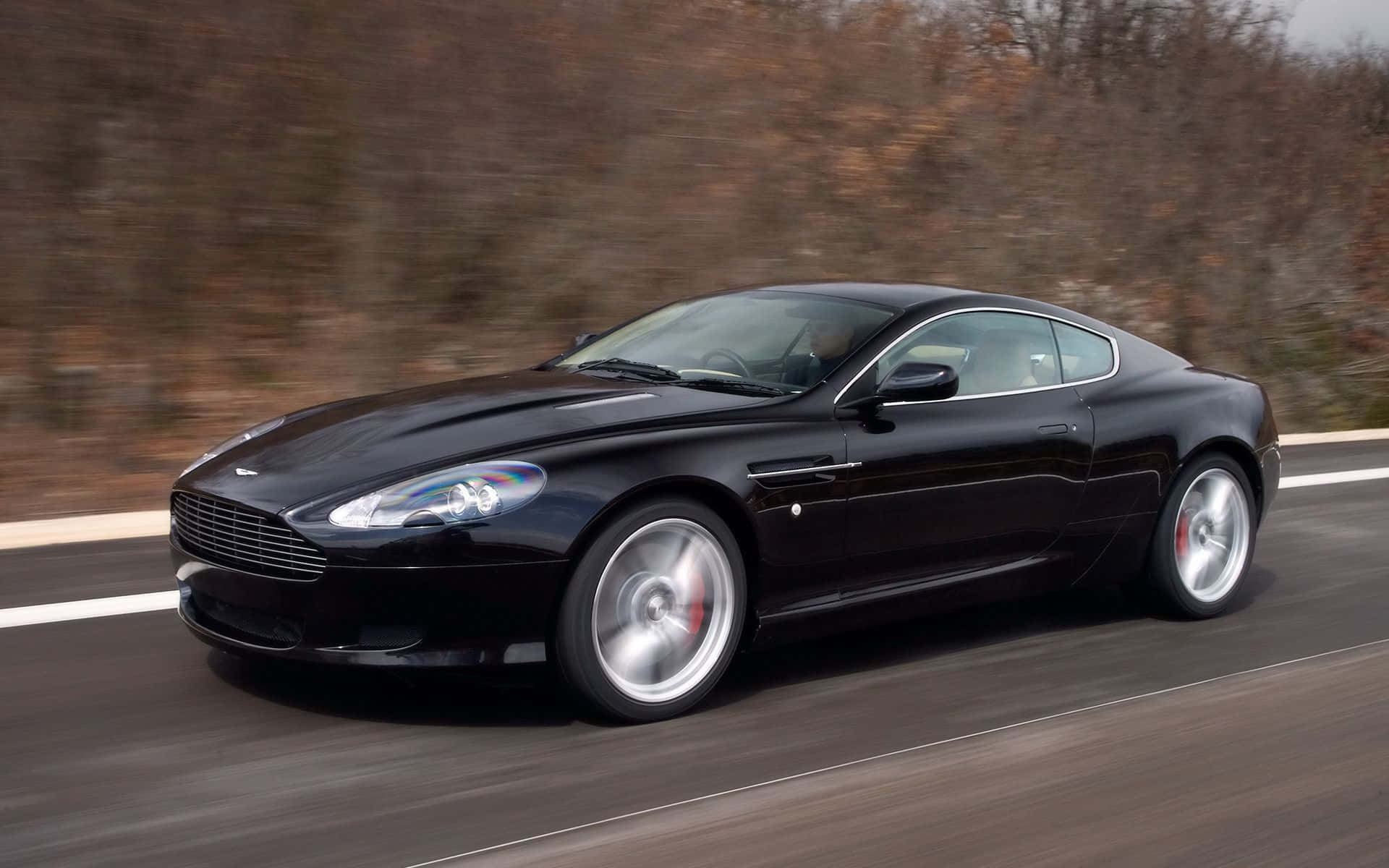Tyylikäs Aston Martin DB9 avoimella tiellä Taustakuvat
