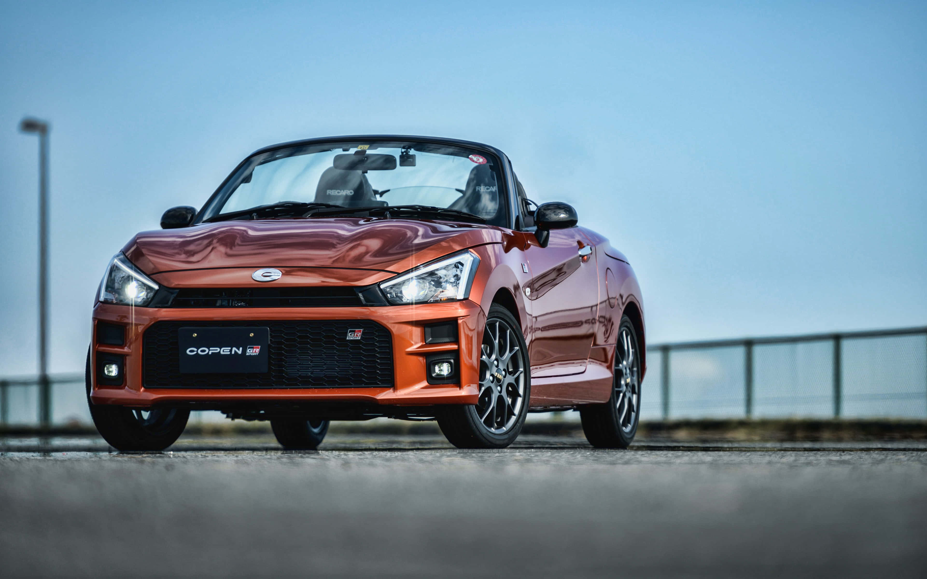 Tyylikäs Daihatsu-auto ajaa avoimella tiellä Taustakuvat
