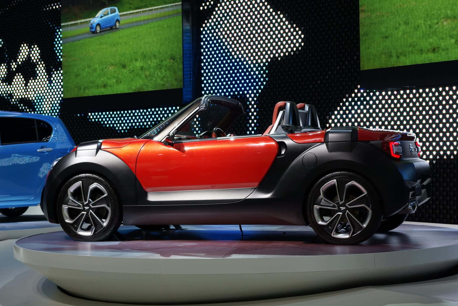 Tyylikäs punainen Daihatsu avoimella tiellä Taustakuvat