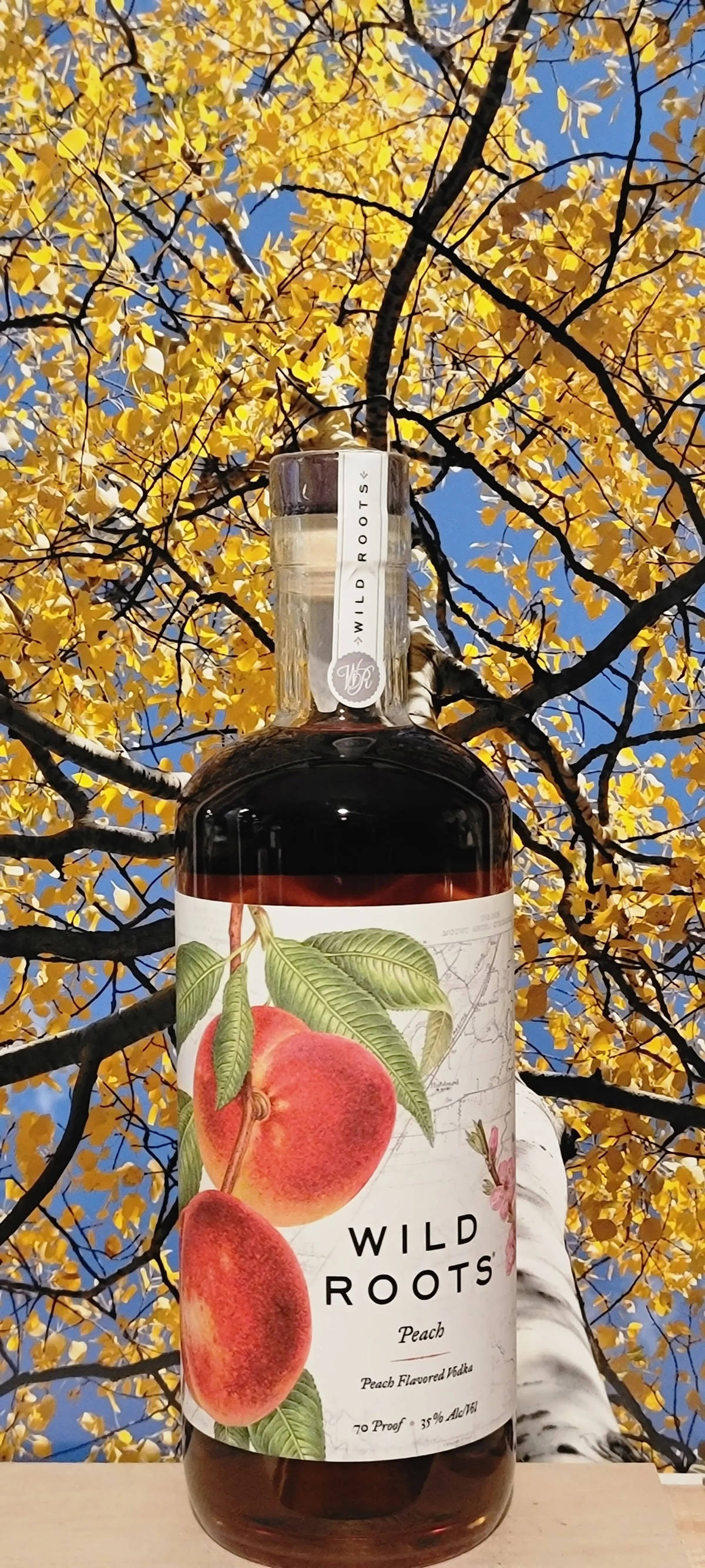 Virvoittava persikkavodka Wild Rootsilta Taustakuvat