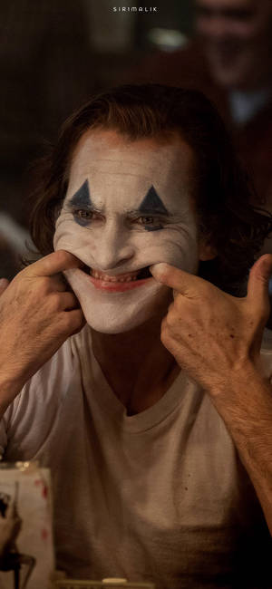 Arthur tekee iloisen naaman ilmeen elokuvassa Joker 2019 -taustakuva — iPhone 12 Pro Taustakuvat