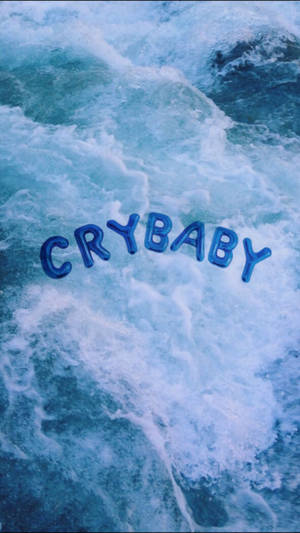 Viileä sininen esteettinen taustakuva, jossa isot ilmapallokirjaimet lukevat 'Crybaby' kelluen sinisellä merellä.