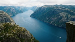 Mahtava vuononäkymä jyrkkine kallioineen ja sumuisen veden kanssa.